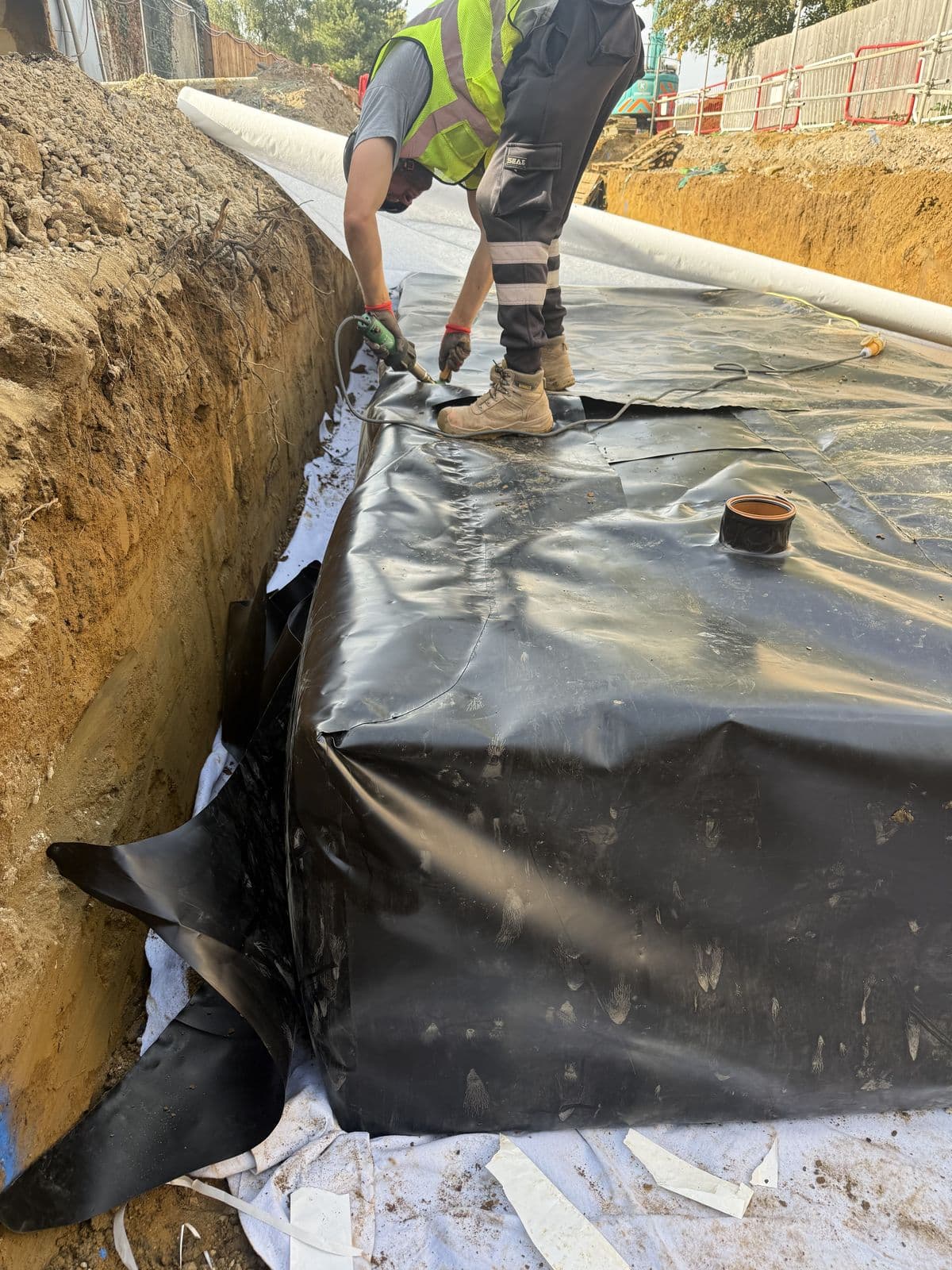 Aquatech operative wrapping the membrane over the crates at the Cottenham tank