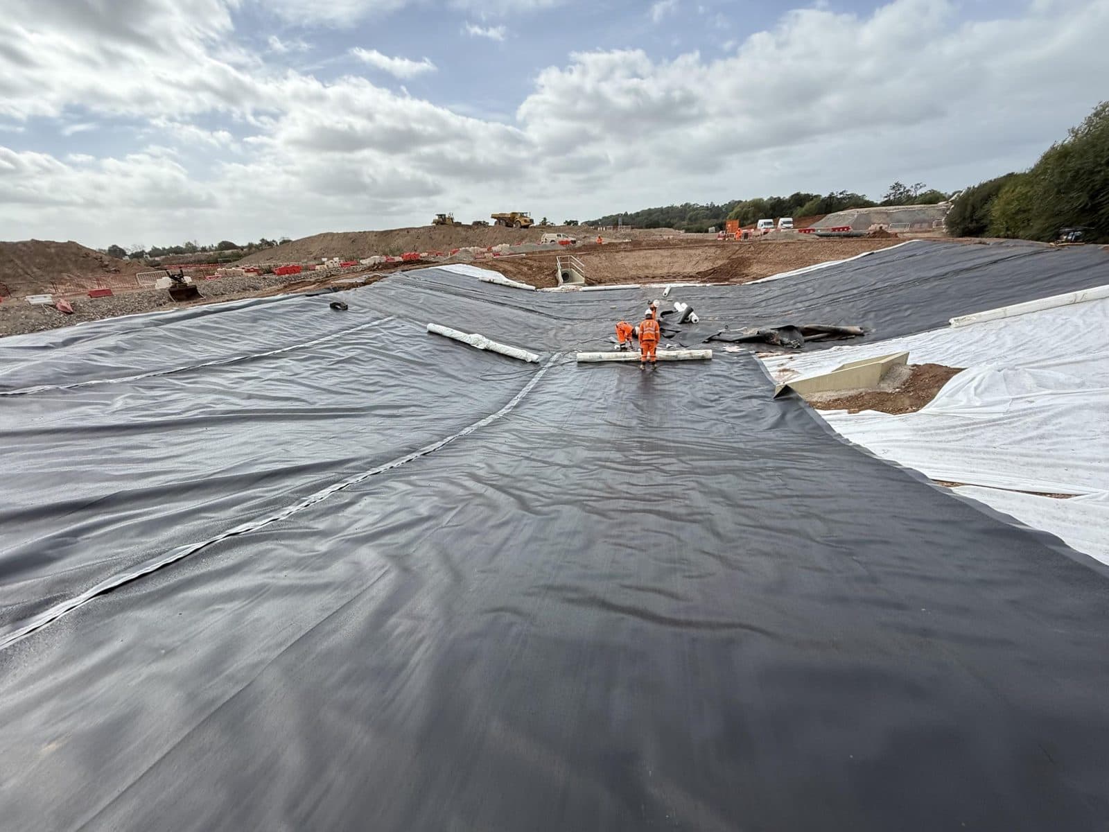 Welded 1mm HDPE panels laid over geotextile across the HS2 pond near Coventry