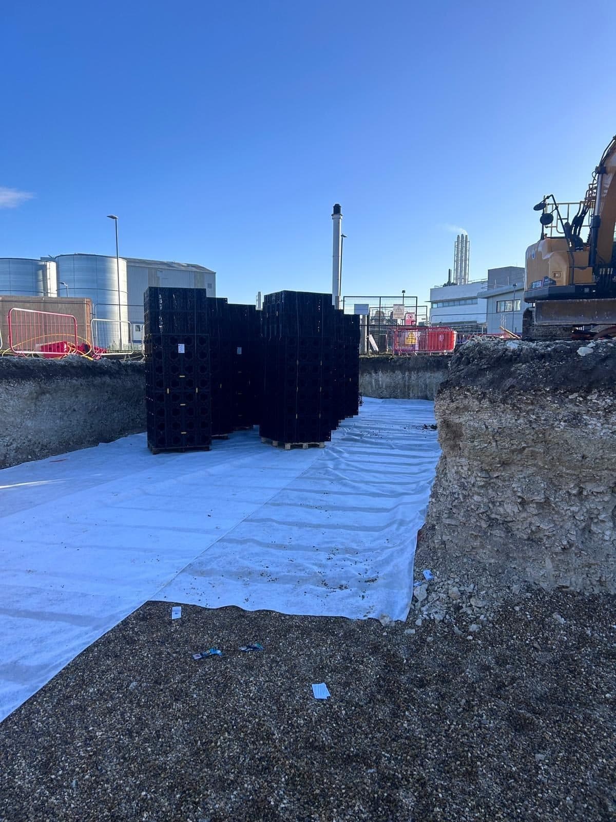 Geocellular soakaway crates staged on a geotextile-lined excavation