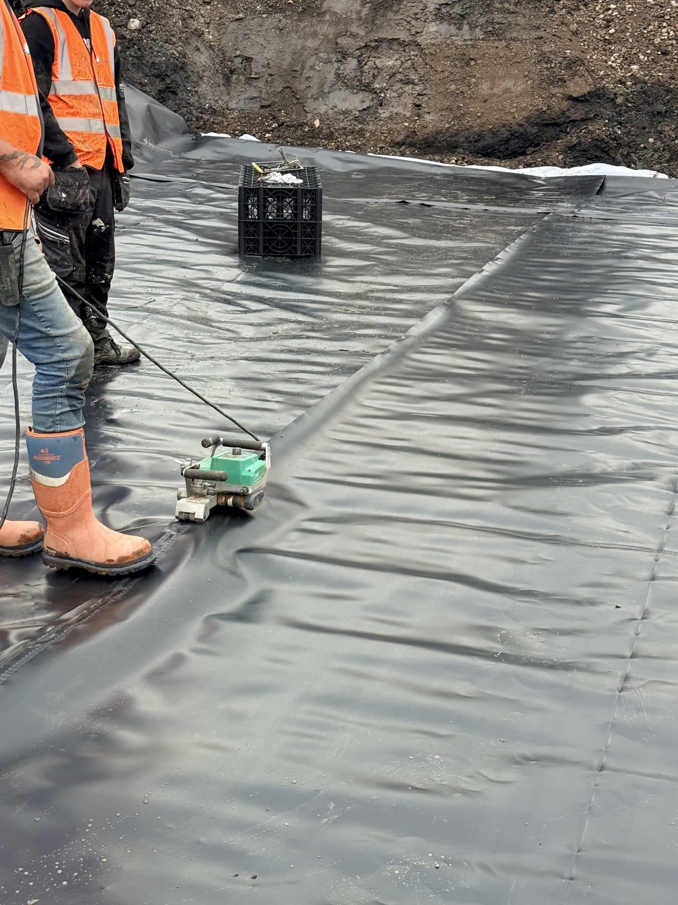 A wedge welder running a heat-welded seam along a membrane panel